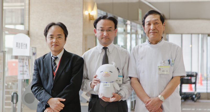 福岡聖司さん、スタッフお二人とHMネットイメージキャラクター ぽぽじろう